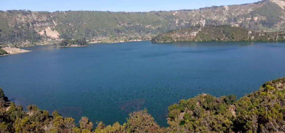 A panoramic view of Wonchi Crater Lake surrounded by lush green hills.